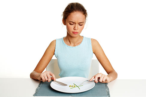 Thin young woman with clean plate