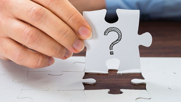 man holding jigsaw puzzle with question mark on it