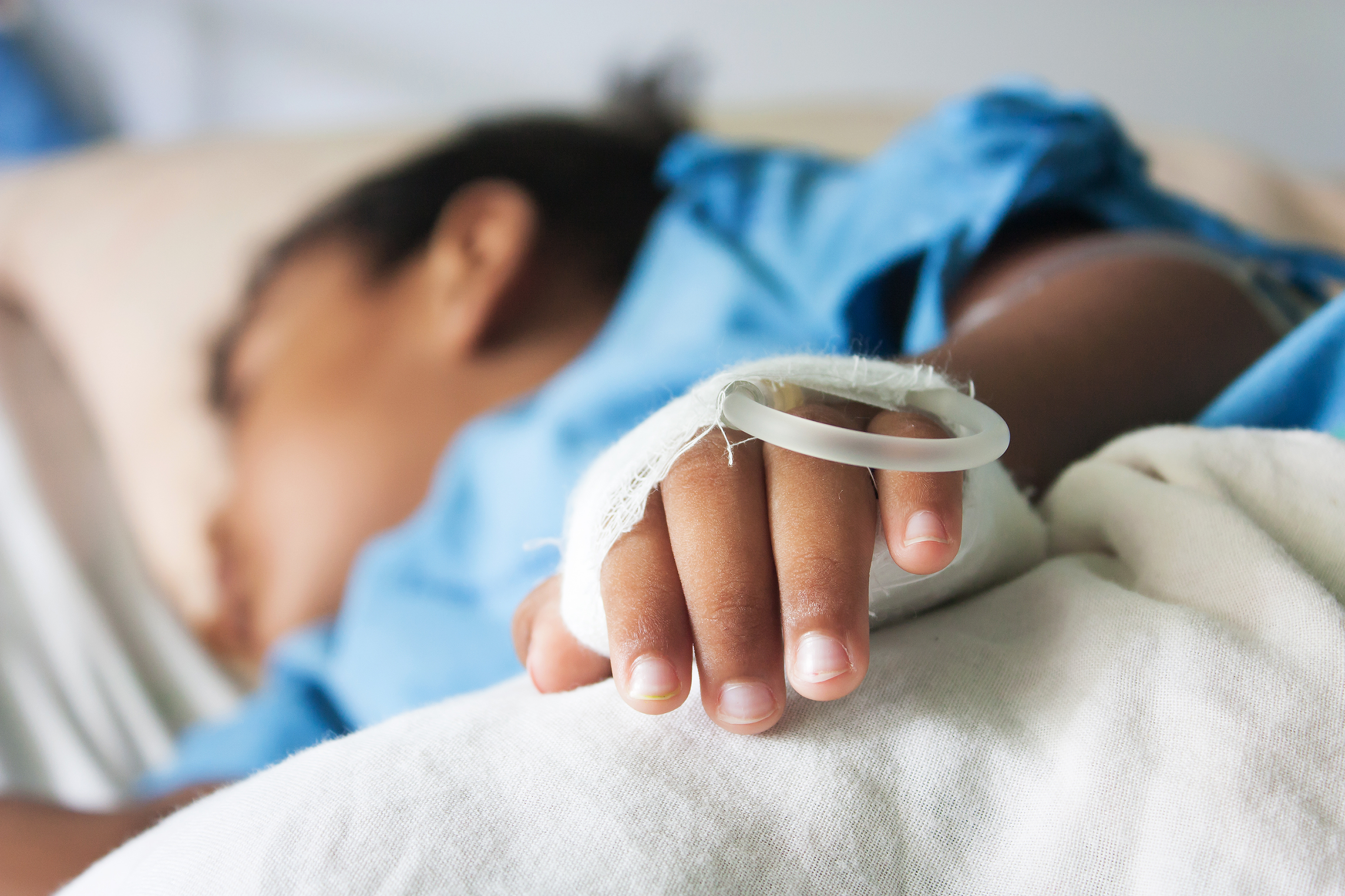 young child with IV drip in hospital
