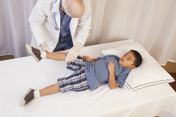Doctor examining boy's leg