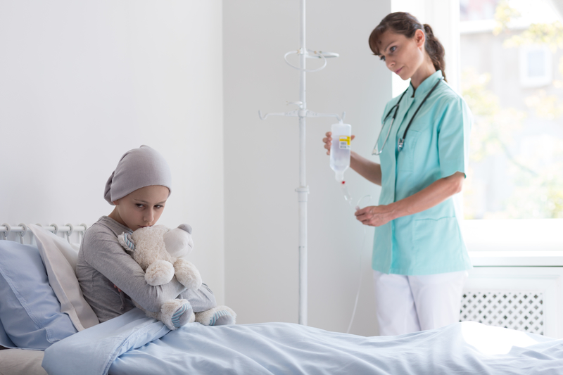 child with cancer in hospital with nurse