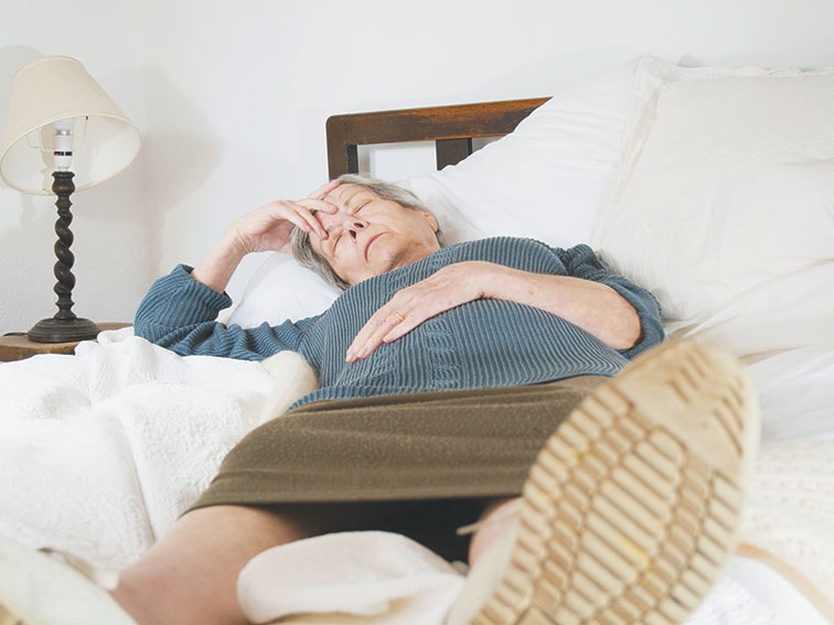 Senior woman bed sick headache