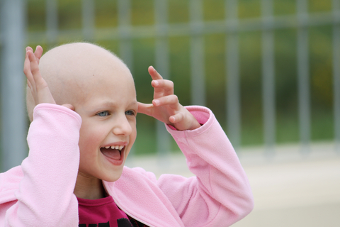 happy child with hair loss due to cancer therapy