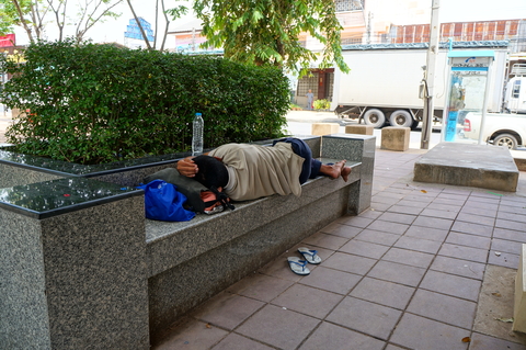 homeless man sleeping on city bench