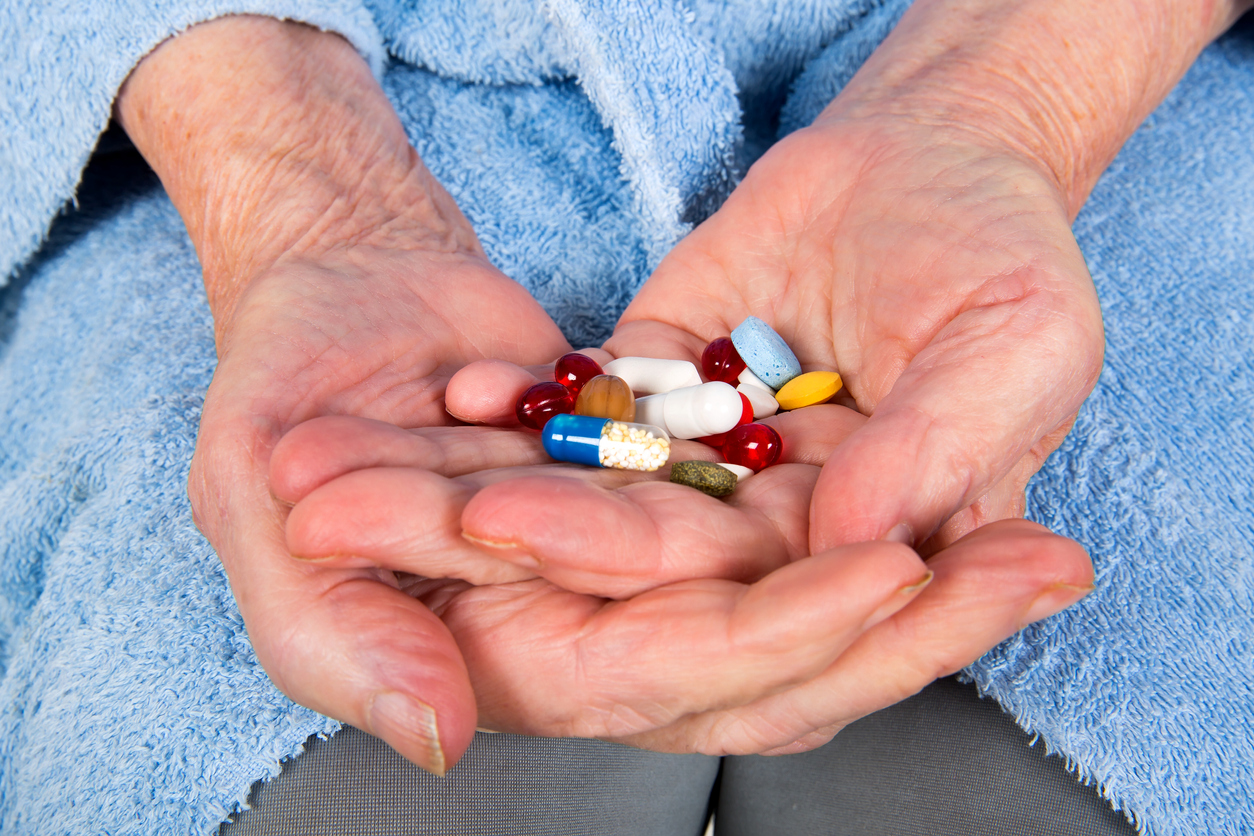 Elderly hands holding lots of medication