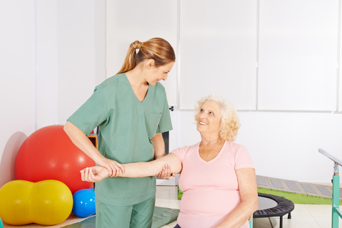 senior woman working with physiotherapist