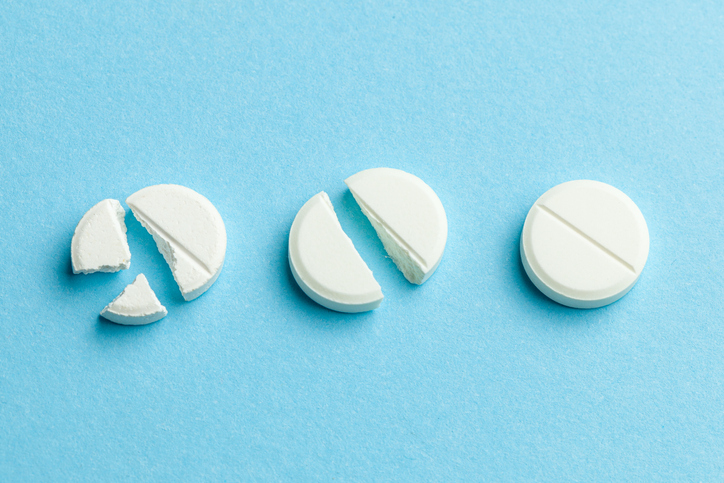 pills broken into halves, quarters - concept of dose