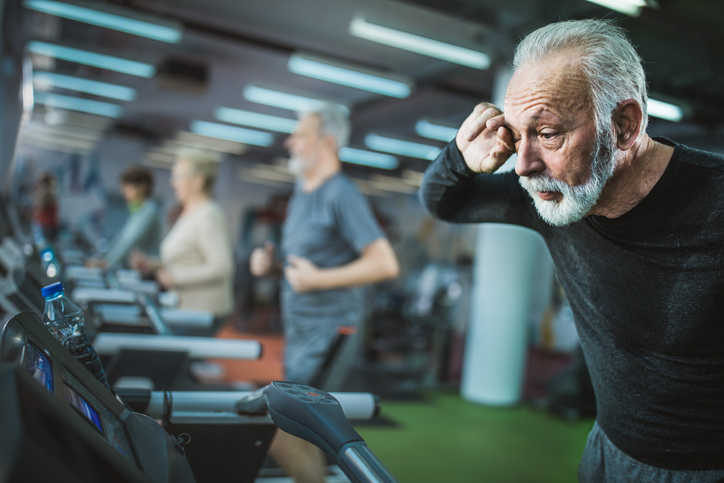 senior man looking tired on exercise treadmill