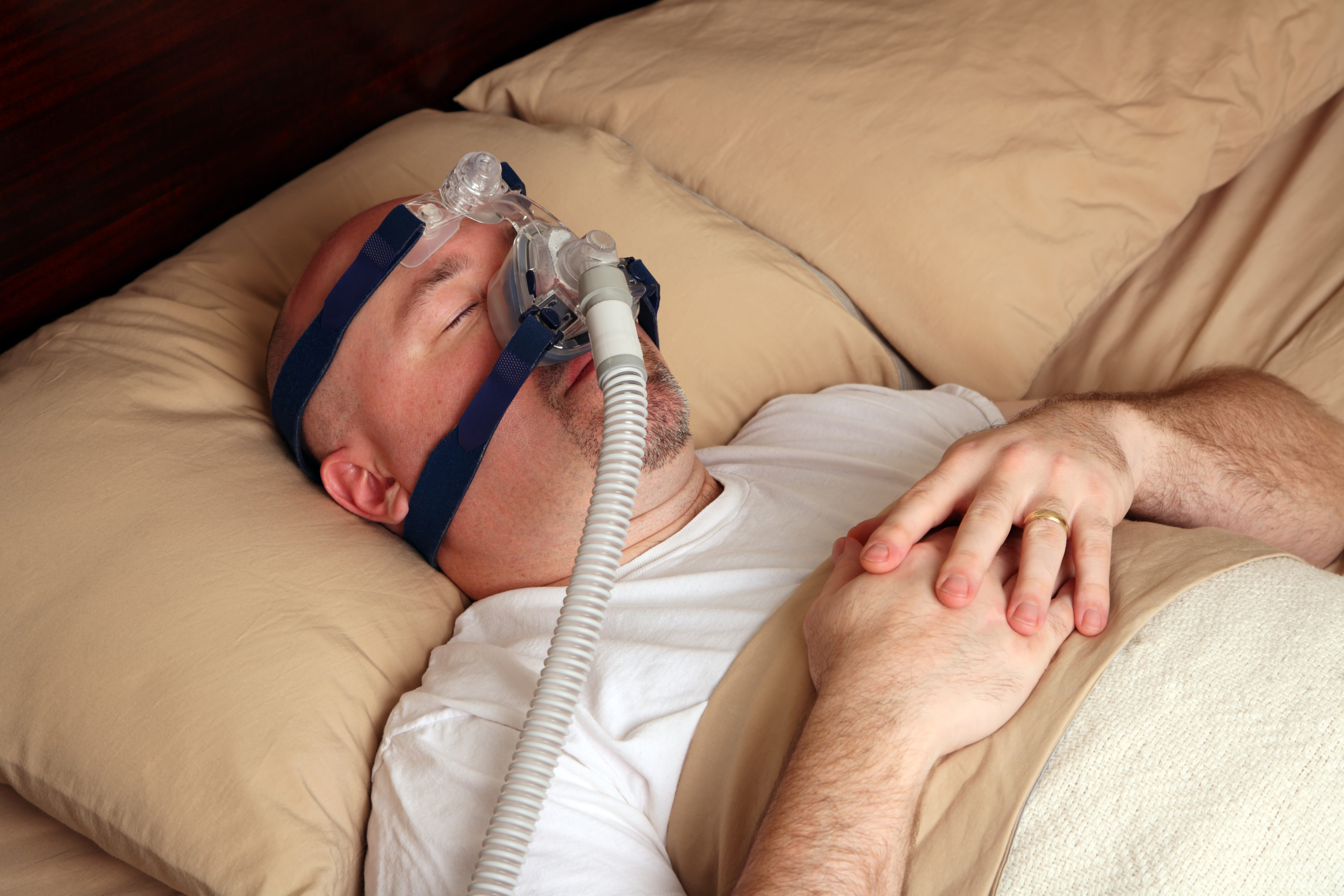 man using CPAP in bed